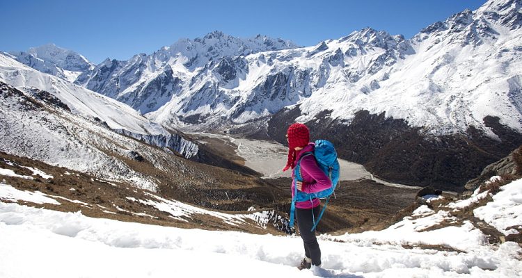 A girl surveys the Langtang valley from the top of Kyanjin Ri with the peak of Ganchempo far in the distance, Langtang Valley, Himalayas, Nepal, Asia